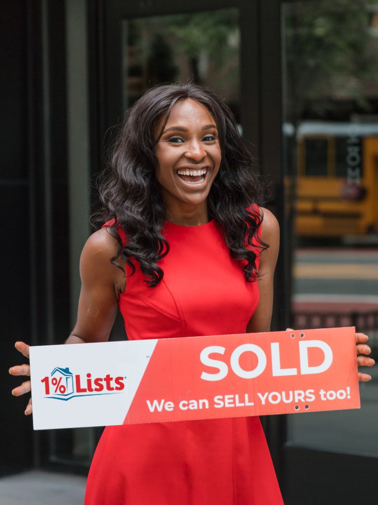 Client holding a 1 Percent Lists sold sign